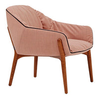 Blush pink upholstered chair with contrasting black piping and light wooden legs, featuring a minimalist design.