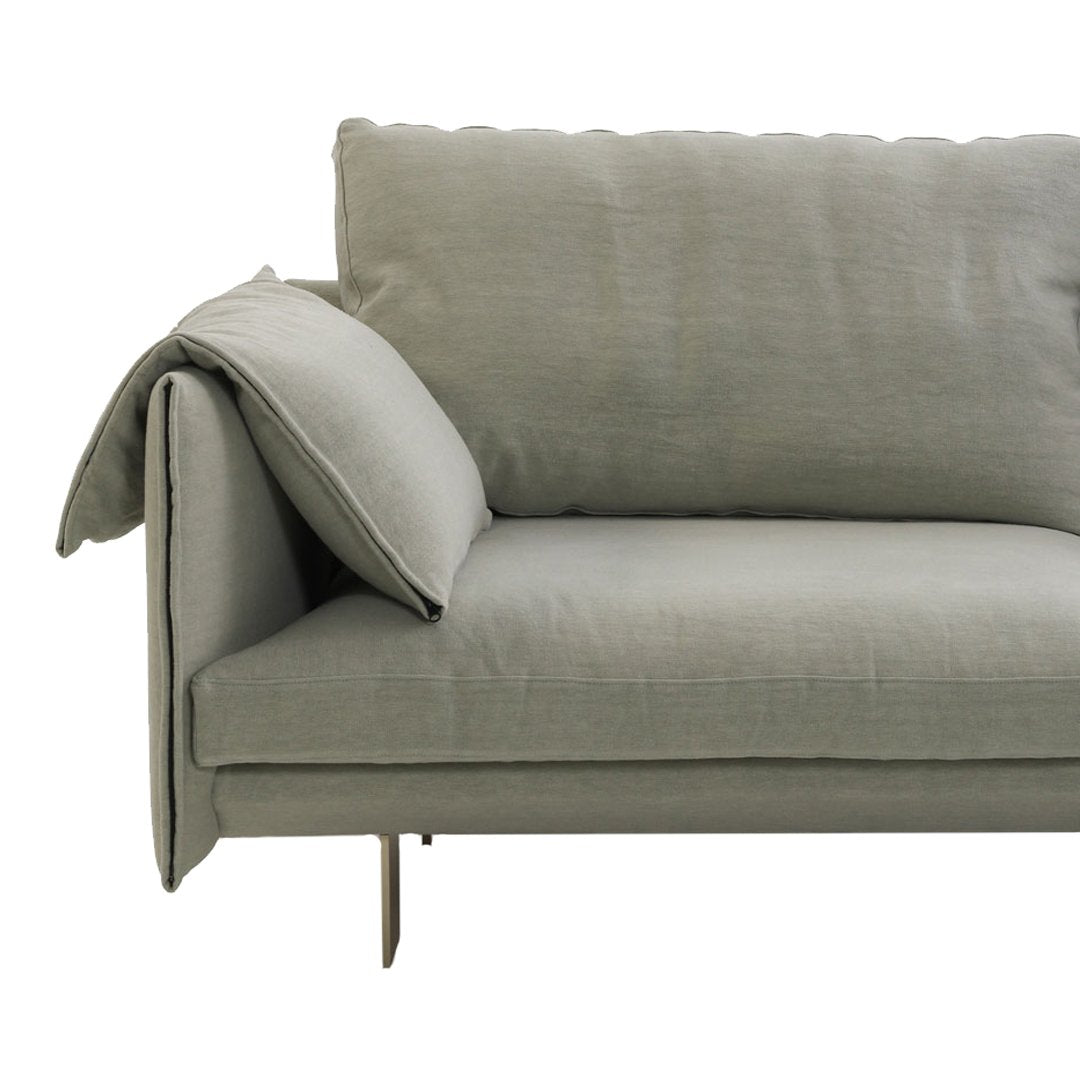 Soft gray fabric sofa with a minimalist design and subtle texture, featuring a cushion elegantly draped over the armrest.