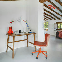 Orange and red checkered vase and chair against a minimalist white backdrop with wooden beams.