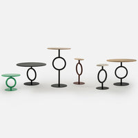 Colorful modern side tables featuring green, black, brown, and natural wood finishes with sleek circular patterns.