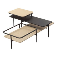 Modern coffee table with a minimalist design, featuring light wood and black surfaces in simple, geometric shapes.
