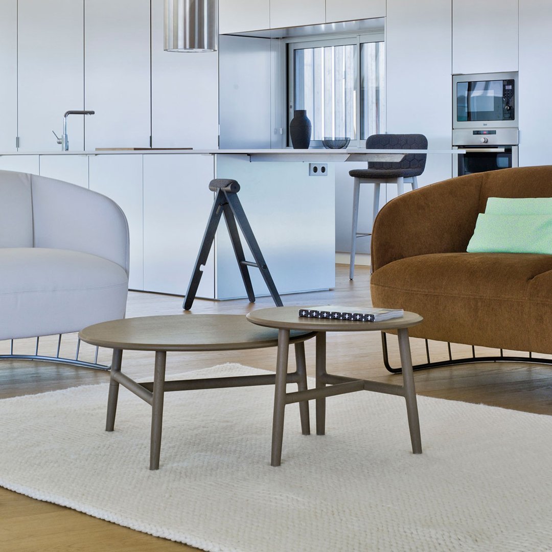 Modern coffee table with a sleek gray surface and minimalist design, complemented by soft, neutral-toned furniture.