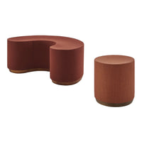 "Curved rust-colored sofa and matching round stool with textured fabric and wood accents."