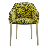 Chic armchair with a vibrant yellow pattern and black abstract designs on a light-colored frame. Ideal for bold decor.