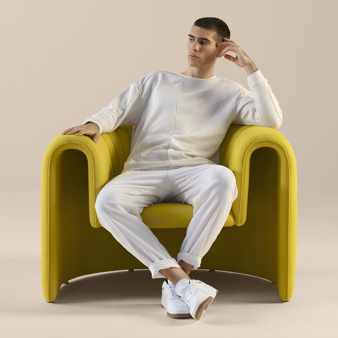 White loungewear set paired with a vibrant yellow modern chair against a neutral backdrop.