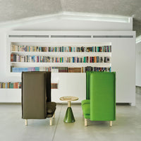 Green and brown upholstered chairs with a modern design and a round, green accent table in a sleek, minimalistic setting.