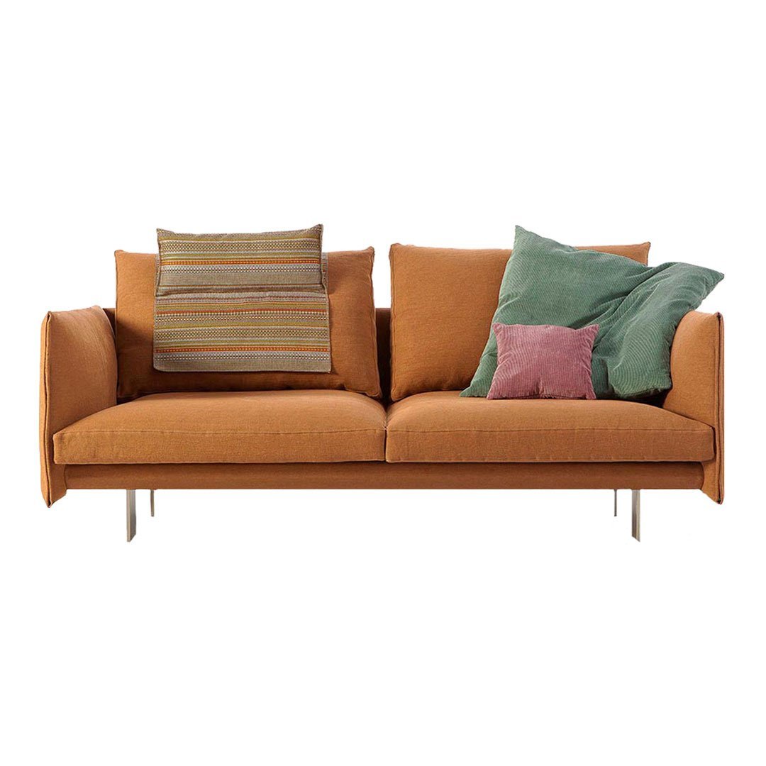 Orange sofa with textured pillows in green, purple, and multicolored stripes for a modern, vibrant look.