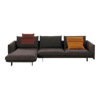 Dark gray sectional sofa with striped and solid orange throw pillows for a modern, stylish look.