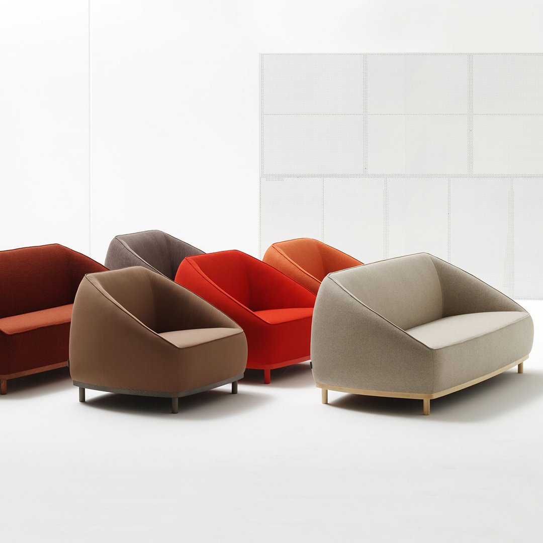 Colorful modern sofas in shades of red, orange, brown, and gray with smooth, geometric patterns.