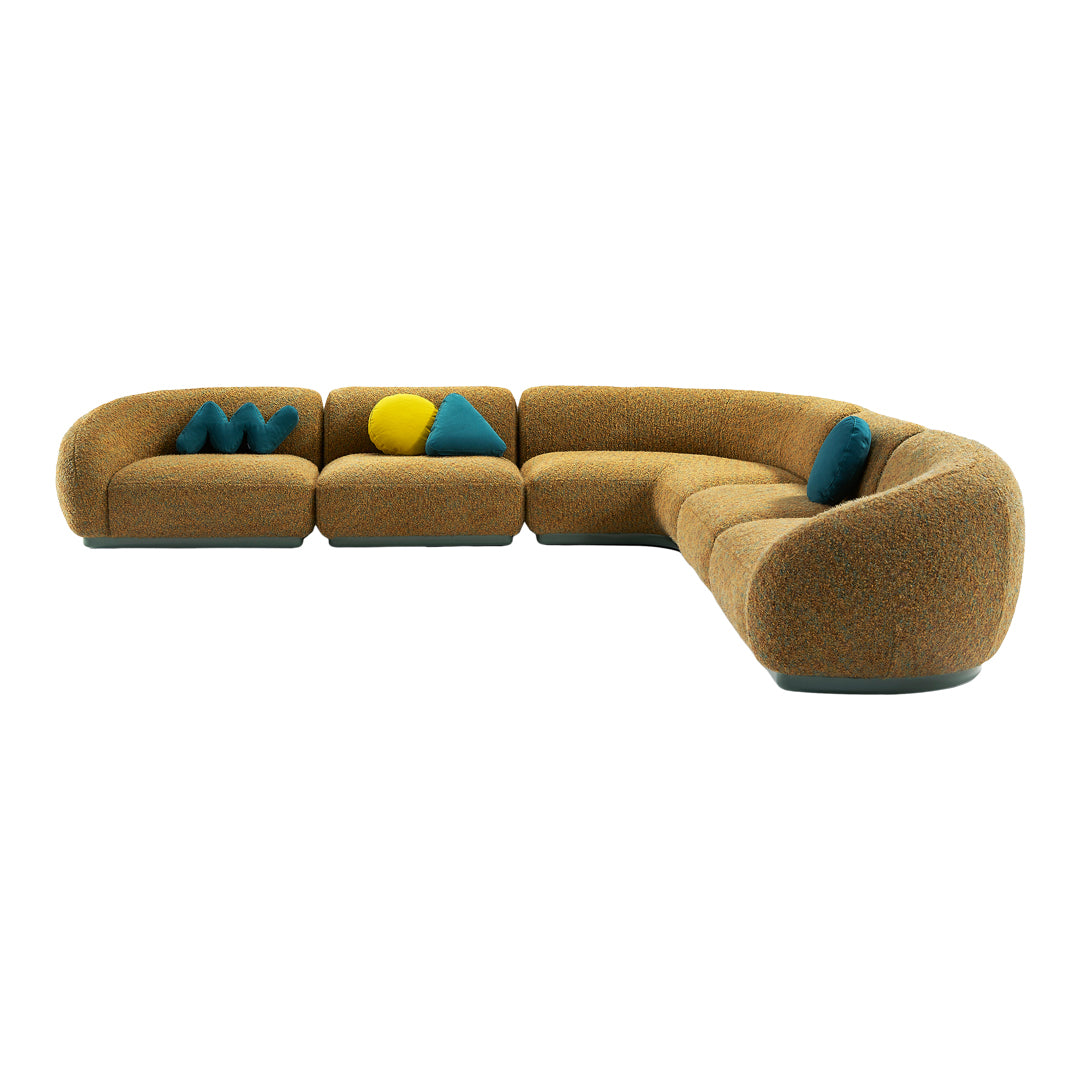 Curved mustard yellow sofa with teal and yellow geometric accent pillows. Soft texture and vibrant colors enhance decor.