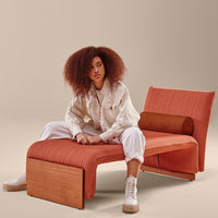 Rust-orange lounge chair with ribbed texture and wooden accents, perfect for modern interiors.
