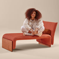Rust orange lounge chair with textured fabric, featuring smooth wood accents. Stylish modern design for any space.
