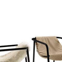 "Two modern chairs: one with a soft, white fur seat and the other in a sleek, beige fabric with black metal frames."