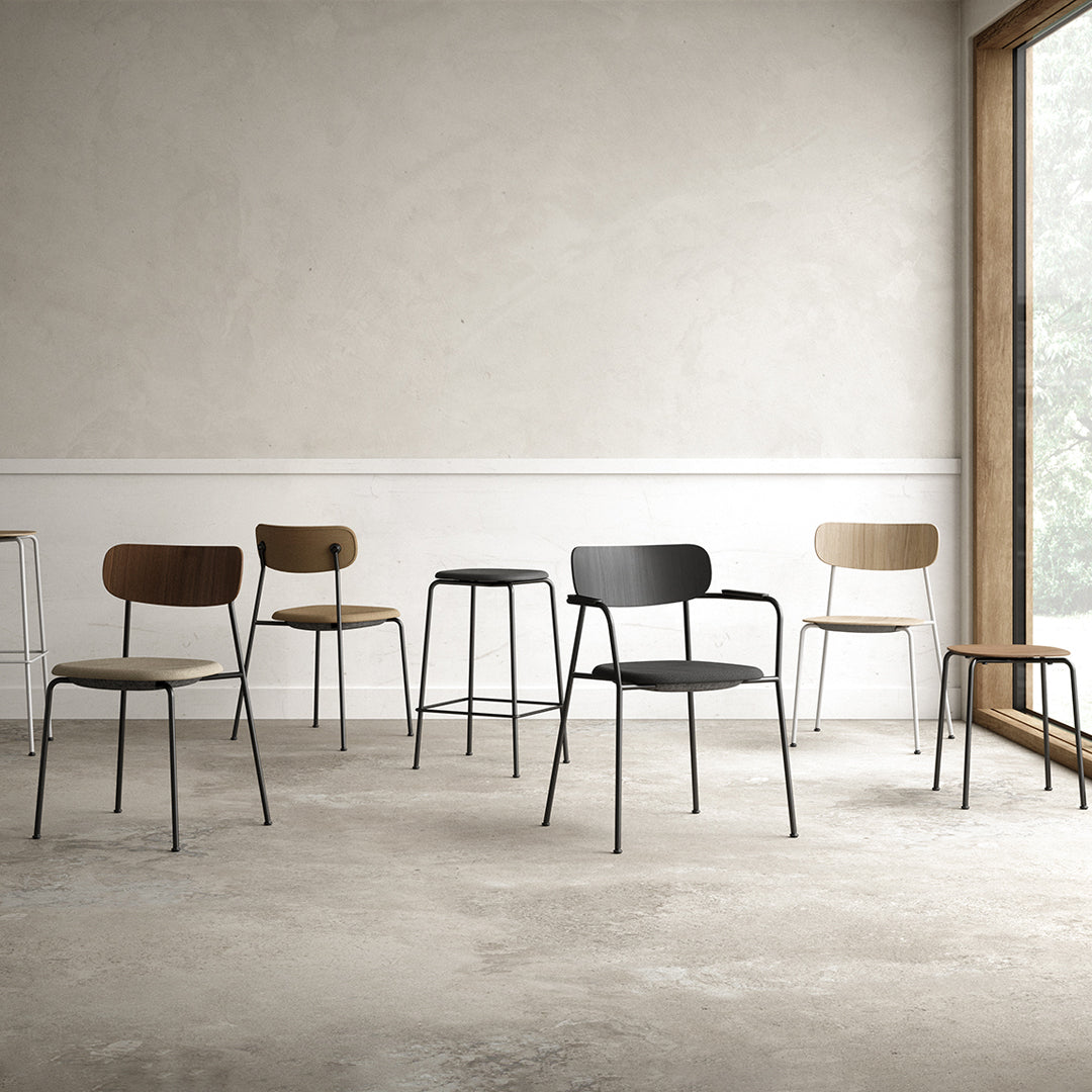 Set of minimalist chairs in black, brown, and light wood hues with sleek metal frames, arranged in a modern space.