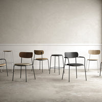 Various modern chairs in wood and metal, featuring brown, black, and beige colors against a minimalist background.