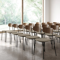 Set of modern chairs featuring a natural wood finish and neutral beige upholstery on slender black legs.