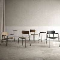 Assorted modern chairs in natural wood, dark wood, and sleek black finishes against a minimalistic backdrop.