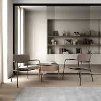 Modern lounge chairs in muted taupe and black, featuring clean lines and minimalist design, set in a contemporary room.