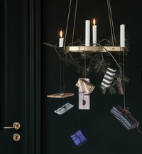Elegant hanging decor with white candles, gold accents, and gift boxes in black, white, and purple striped patterns.