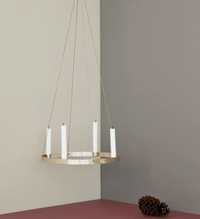 Modern chandelier with a gold finish and white candle holders, set against a neutral color palette of beige and gray.