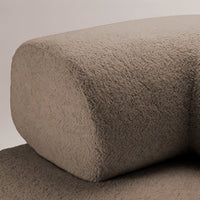 Textured beige cushion with a soft, velvety surface, highlighting subtle variations in color and pattern.