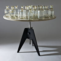 "Clear glass jars on a round wooden table with a sleek black tripod base, creating a modern aesthetic."