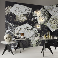 Geometric black and white patterned wall with glossy surfaces and modern table decor in neutral tones.