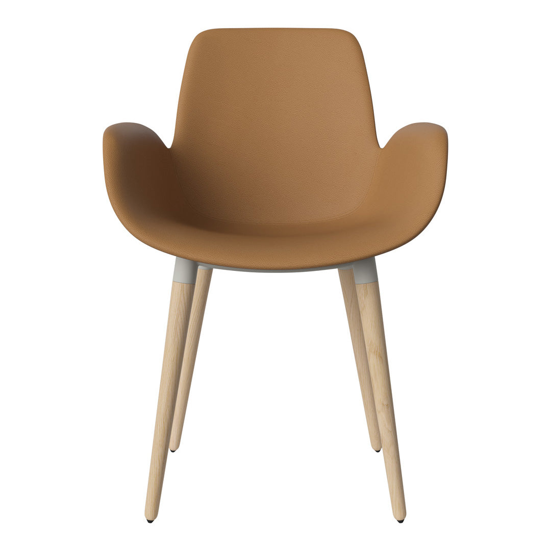 Tan armchair with wooden legs and smooth finish, offering a modern and minimalist design. Perfect for any decor.