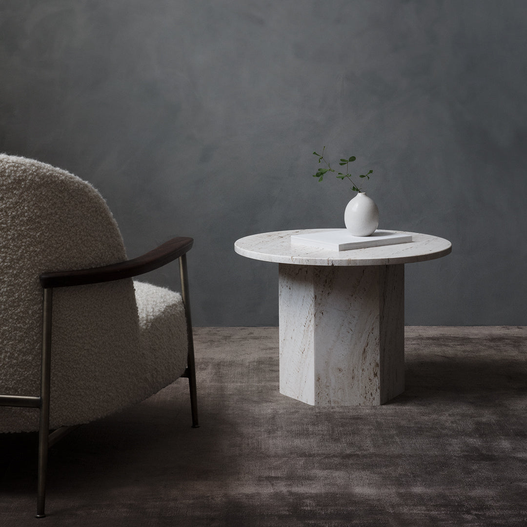 White textured round table with subtle gray veining, paired with a minimalistic white vase on a muted gray backdrop.