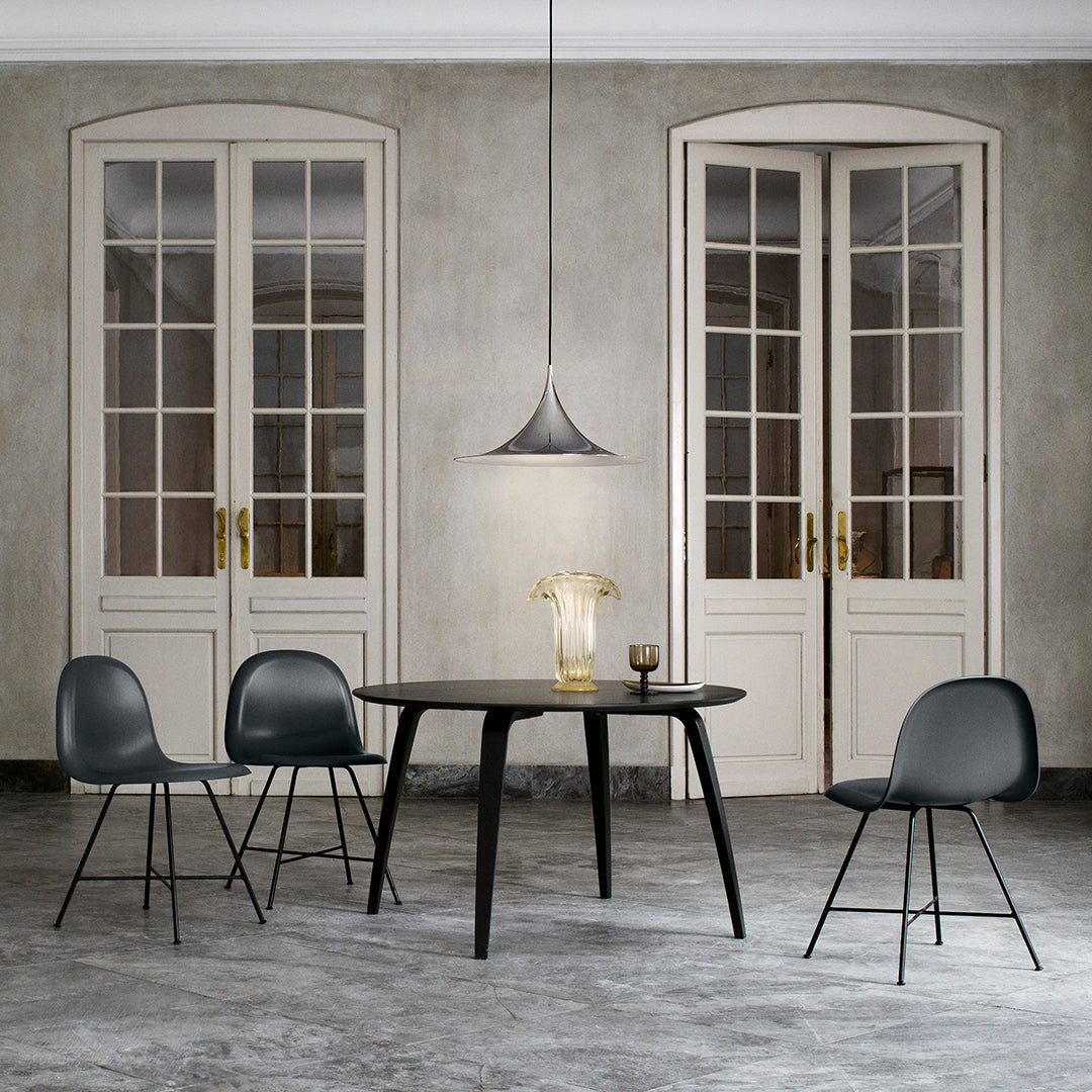 Elegant black dining table with sleek black chairs and neutral gray walls, featuring soft natural light.