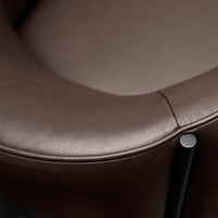 Close-up of a brown leather chair featuring smooth texture and sleek black metal accents. Perfect for modern decor.