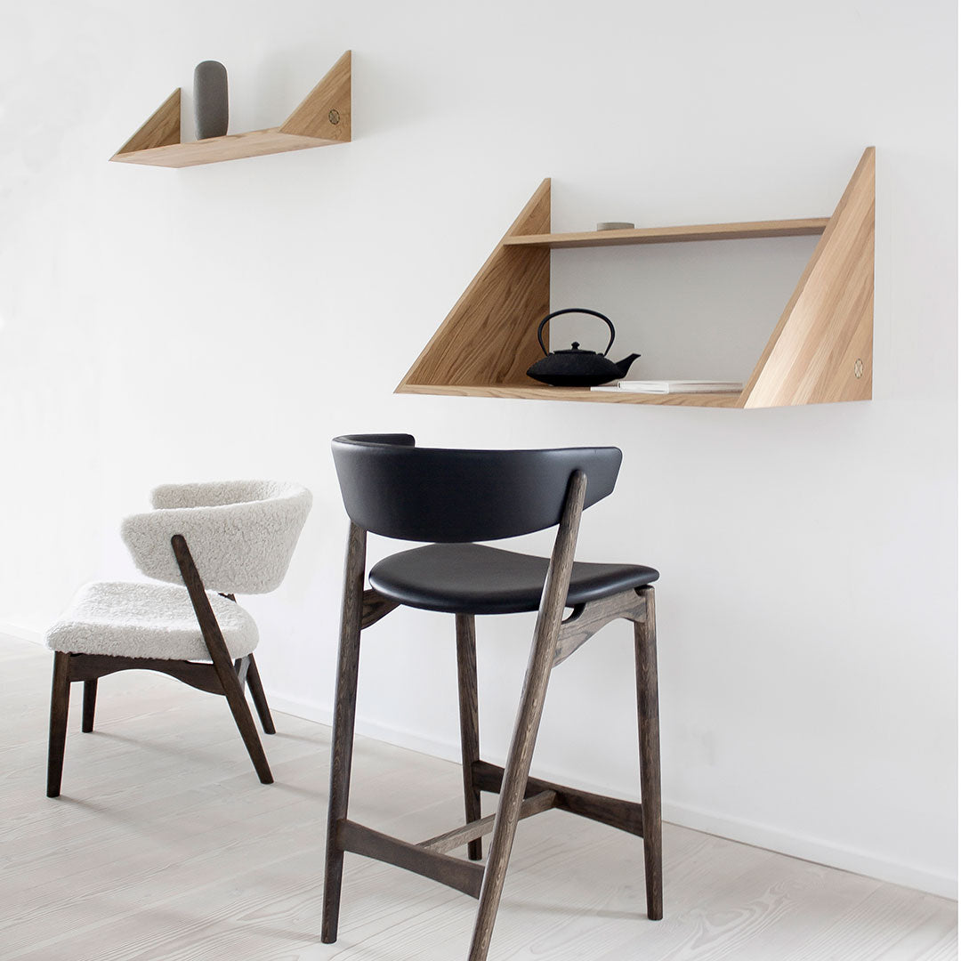 Modern black and white chairs with light wood shelves, featuring clean lines and minimalist design against a neutral wall.