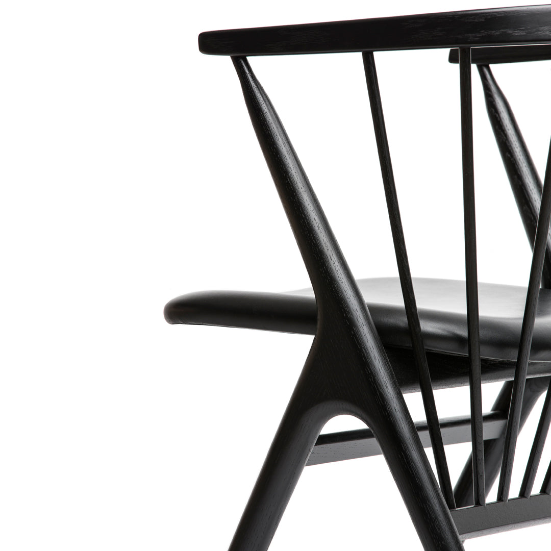 "Modern black chair featuring sleek lines and a minimalist design with a polished finish."