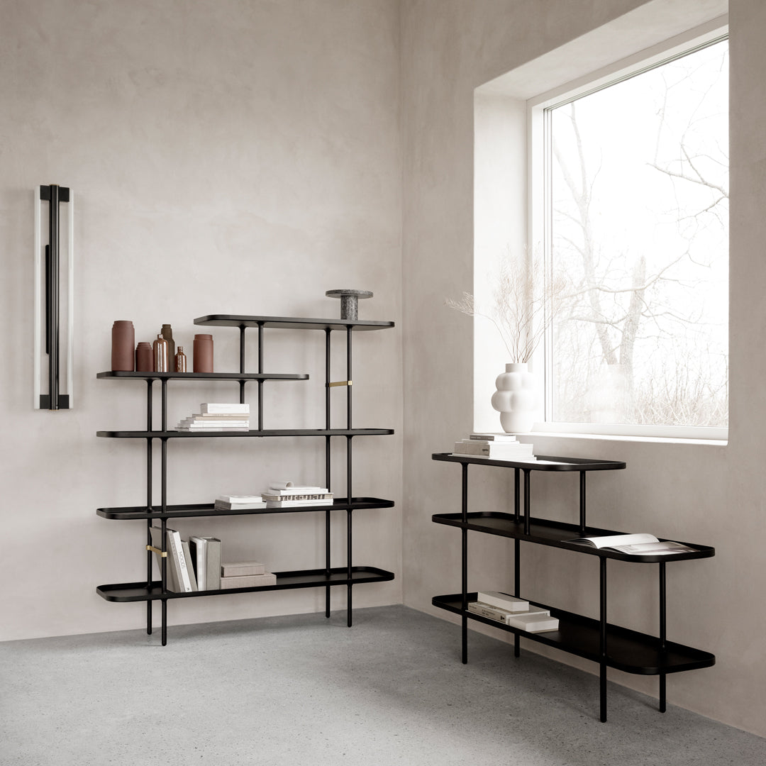 Modern black metal shelving units with clean lines and minimalist design, set against a neutral gray wall.