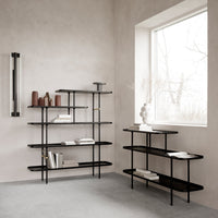 Modern black metal shelving units with clean lines and minimalist design, set against a neutral gray wall.