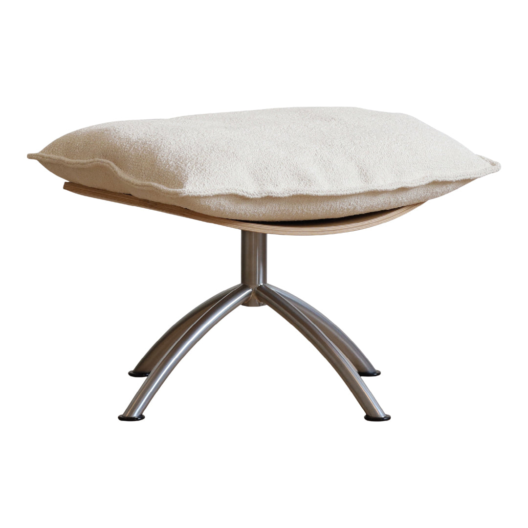 Cream plush cushion atop a sleek, silver metal base with a minimalist wooden structure. Modern and stylish design.