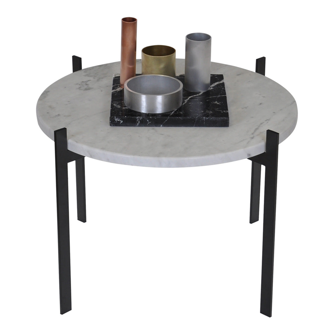 Round marble table with black metal legs, featuring gray, silver, and gold decorative accessories on a dark tray.