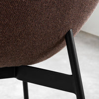 Brown textured fabric with a subtle pattern, complemented by sleek black metal legs. Ideal for modern decor.