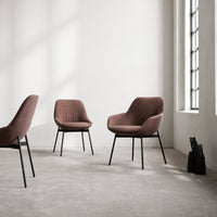 "Set of three plush, terracotta-brown chairs with textured upholstery and black metal legs against a minimalist backdrop."