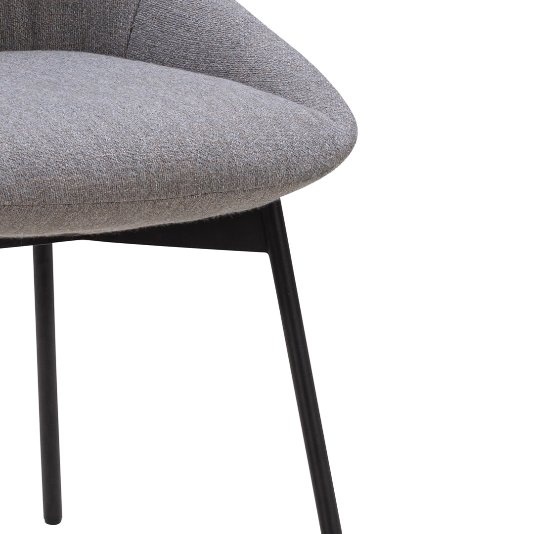 Gray upholstered chair with a smooth, rounded seat and sleek black legs, showcasing a minimalist design.