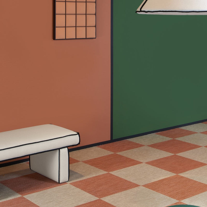 Colorful green and terracotta walls with checkerboard floor in shades of cream and burnt orange, creating a vibrant interior.