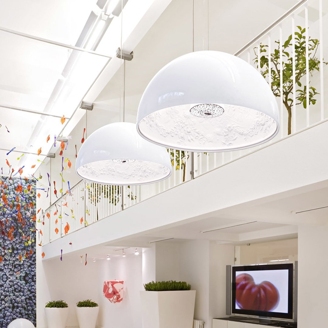 White dome pendant lights with intricate patterned shades, enhancing a modern, vibrant interior space.