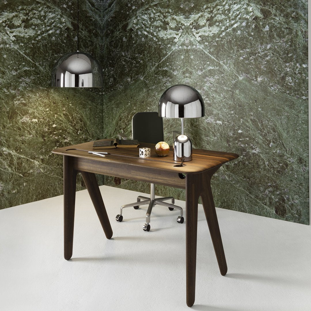 Sleek dark wood desk with a smooth surface, complemented by metallic accents and an abstract green patterned wall.