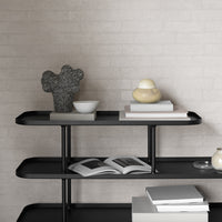 Black metal shelves with a minimalist design, featuring neutral tones and textured decor elements.
