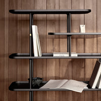 Modern black shelving unit featuring sleek shelves against a warm wooden backdrop. Clean lines and minimalist design.
