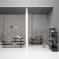 Black metal shelves against a minimalist gray background, showcasing a modern, clean aesthetic with neutral tones.