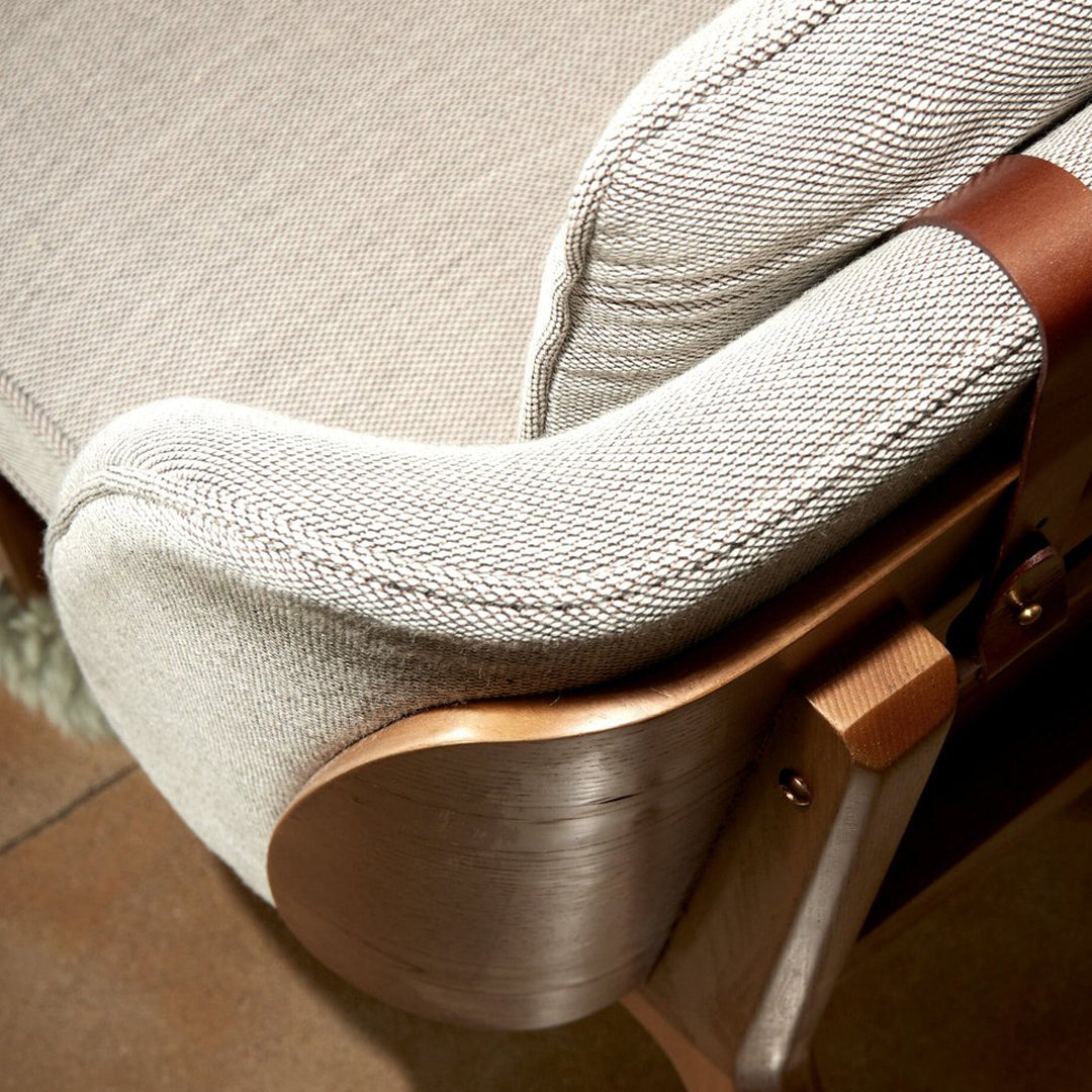 Textured light gray fabric with a subtle herringbone pattern, complemented by a warm wooden finish.