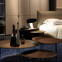 Elegant brown and black furniture with textured patterns, contrasting against a soft blue rug in a modern bedroom setting.