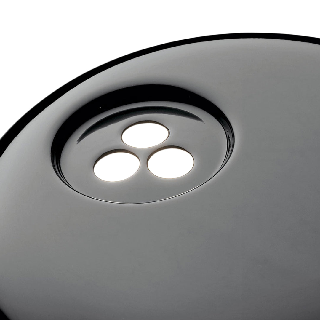 Black round surface with three white circular cutouts, creating a sleek and modern look.