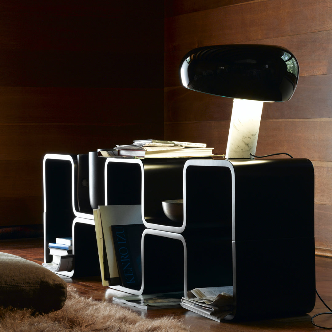 Modern black storage unit with white outlines, featuring geometric patterns and a sleek black lamp for stylish decor.
